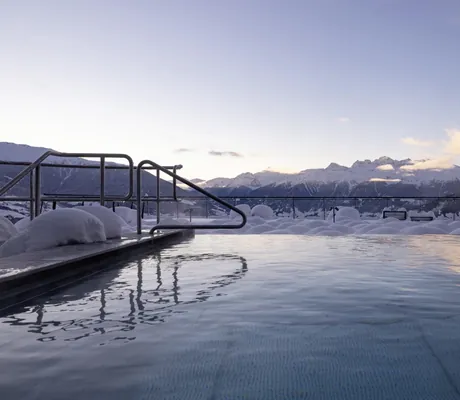 Outdoorpool im tiefen Schnee im Das Gerstl Alpine Retreat mit Blick auf die winterlichen Vinschger Berge