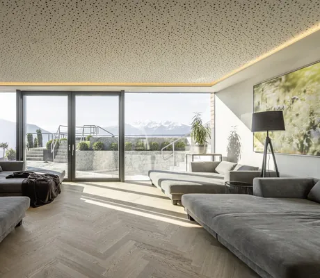 Ruheraum mit großen grauen Liegeflächen und Blick auf die Berge im Das Gerstl Alpine Retreat