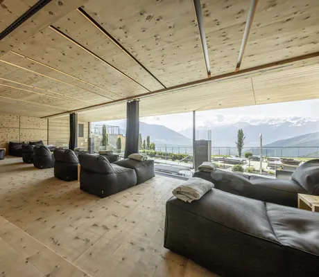 dunkelgraue Liegesäcke im holzvertäfelten Ruheraum mit Blick auf die Berge im Das Gerstl Alpine Retreat