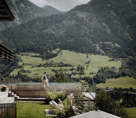 Frau in schwarzem Badeanzug am Outdoorpool des Das.Goldberg neben der Terrasse