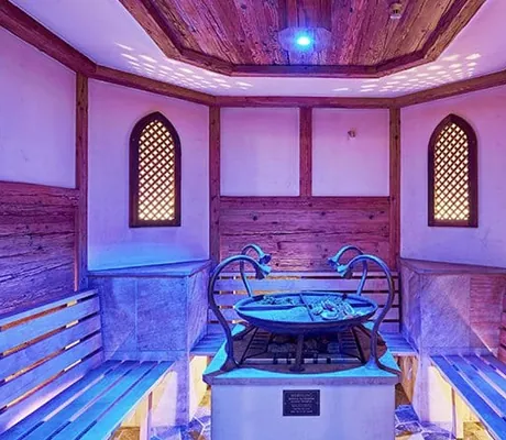 Sauna im Heselbacher Hof mit zwei vergitterten Fenstern und vier Dampfhähnen am Ofen