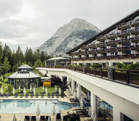 Fassade Interalpen-Hotel Tyrol mit Blick auf den Außenpool und die Hohe Munde