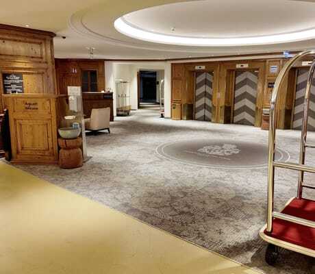 Check-In in der Tiefgarage des Interalpen-Hotel Tyrol mit Holztresen und Rollwagen