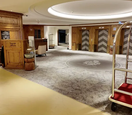 Check-In in der Tiefgarage des Interalpen-Hotel Tyrol mit Holztresen und Rollwagen