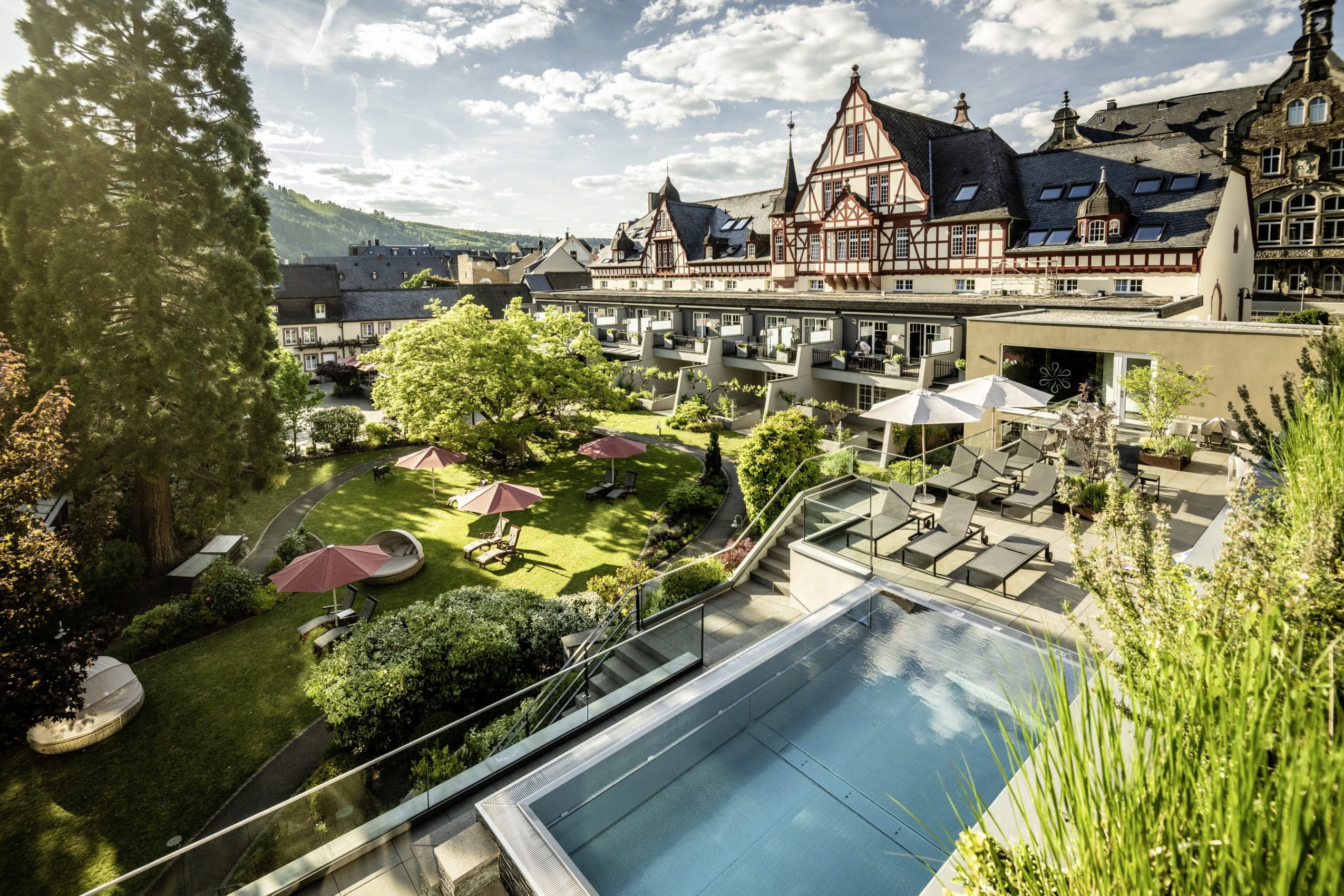 Gesamtansicht Moselschlösschen Spa & Resort mit Blick auf Fachwerkfassade und Outdoorpool