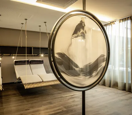 Hängeliegen im Ruhebereich mit großem runden Spiegel im Moselschlösschen Spa & Resort