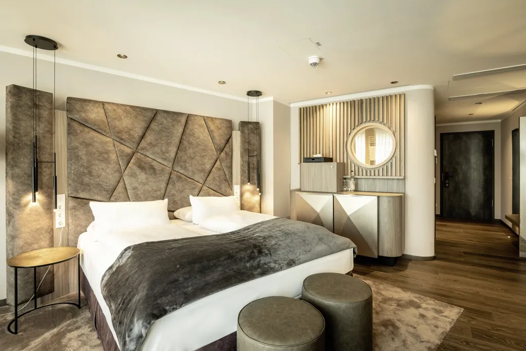 Juniorsuite mit grauer Bettenrückwand und schwarzen Hängeleuchten im Moselschlösschen Spa & Resort