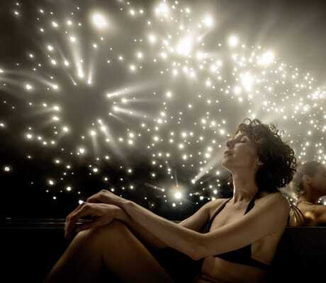 zwei Frauen sitzen im Bikini in einem Raum mit mit hellen Glitzerlichtern im Moselschlösschen Spa & Resort