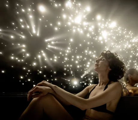 zwei Frauen sitzen im Bikini in einem Raum mit mit hellen Glitzerlichtern im Moselschlösschen Spa & Resort