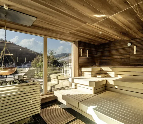 große Sauna im Moselschlösschen Spa & Resort mit dunkler Holzdecke und Kupferkessel