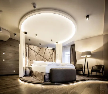 rundes Bett mit runder Lichtinstallation an der Decke in der Suite des Moselschlösschen Spa & Resort
