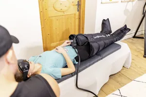 Frau liegt mit VR-Brille und Compression Boots im Biohacking Lab des Posthotel Achenkirch