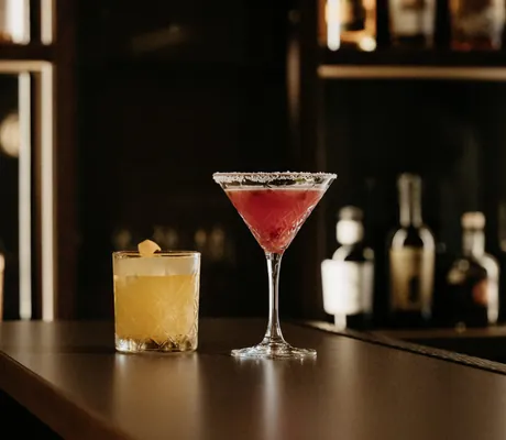 zwei Cocktails stehen auf dem dunklen Bartresen des Terentnerhof