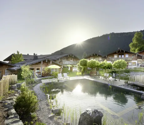 Naturpool in den Alpin Chalets Oberjoch mit Holzbrücke umgeben von Allgäuer Hütten