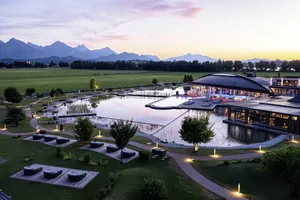 Im Sonnenuntergang stimmungsvoll beleuchteter Wellnessgarten des Hotels Das König Ludwig Inspiration SPA mit Alpenkulisse im Hintergrund