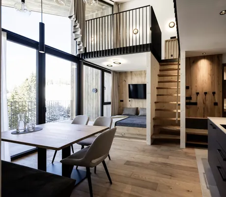 Neues Sky Loft über zwei Stockwerke mit bodentiefen Fenstern, Küchenzeile, Esstisch, Loungebereich und einer Treppe in den zweiten Stock