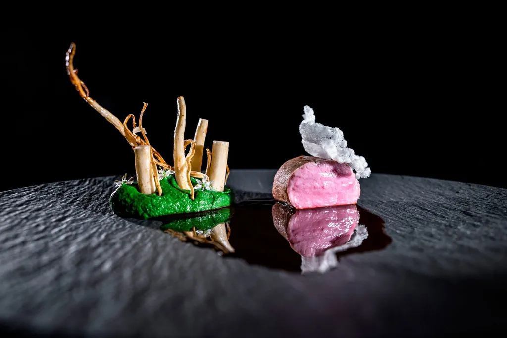 Rosa gebratenes Fleischfilet mit gr&uuml;nem Gem&uuml;se-Arrangement auf schwarzem Schieferstein angericht im Gourmetrestaurant "Atelier Freund-Schafft"