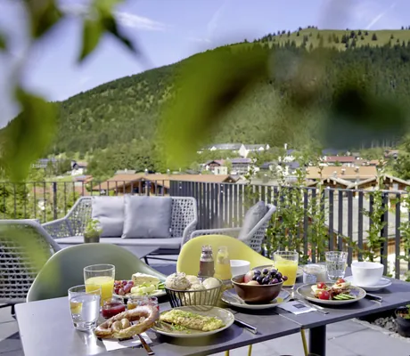 Terrasse mit eingedecktem Frühstückstisch und Blick auf Oberjoch und die umliegenden Berge