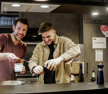 Zwei junge Männer kochen in der Gemeinschaftsküche des BergBuddies-Hotel