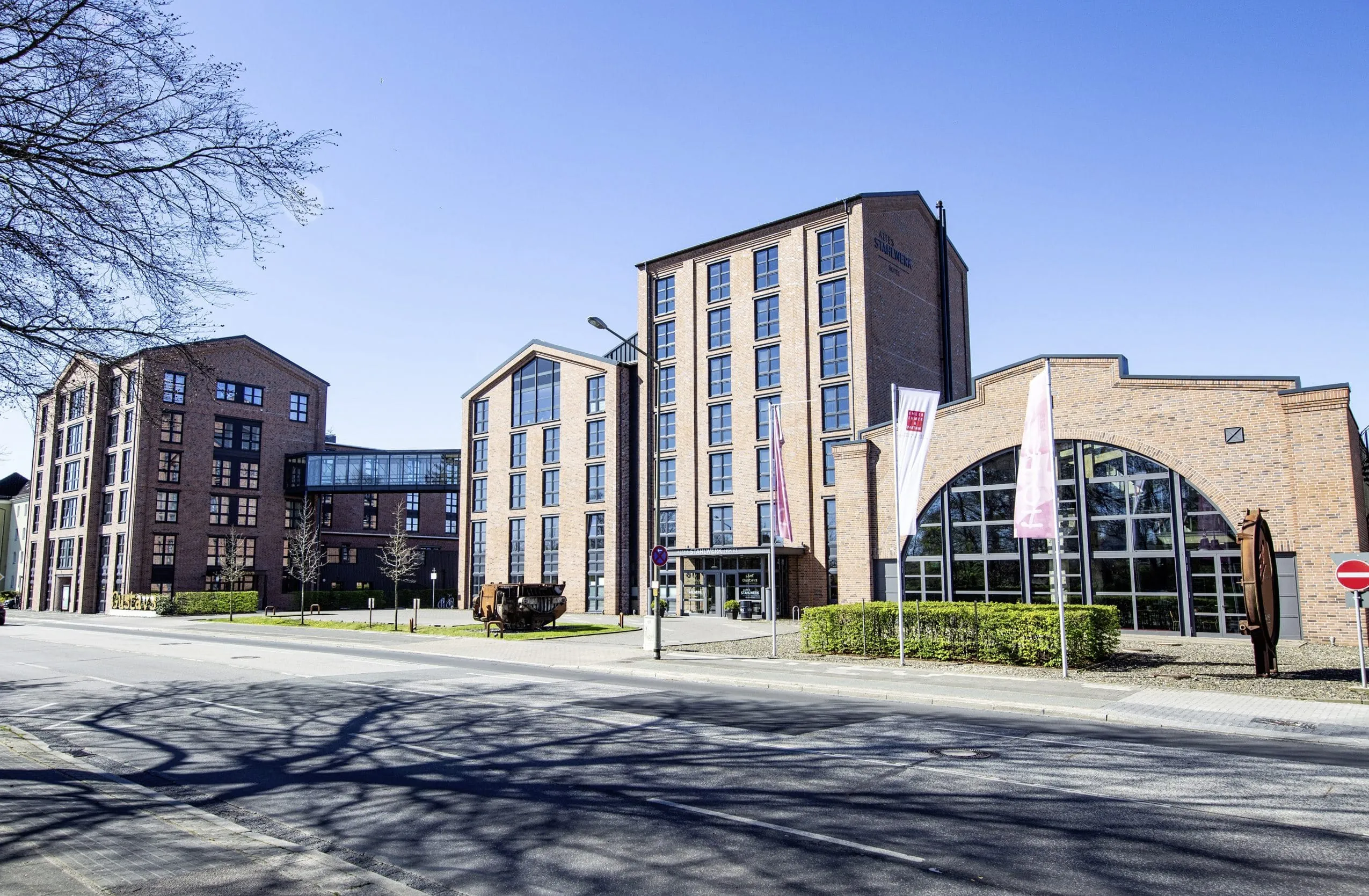 Industrie-Backsteinbau des Altes Stahlwerk mit zwei Fahnenmasten