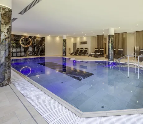 Indoorpool im Flair Park-Hotel Ilshofen mit schwarzen Marmorsäulen und schwarzen Liegen