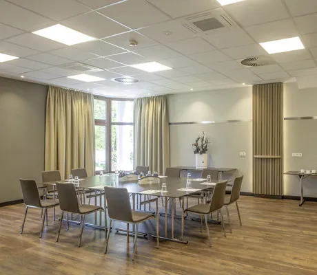 Besprechungsraum im Flair Park-Hotel Ilshofen mit großem Bildschirm und Holzboden