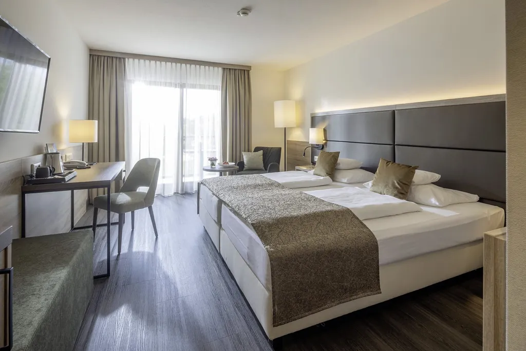 Doppelzimmer im Flair Park-Hotel Ilshofen mit mokkafarbenem Bettrücken und Schreibtisch