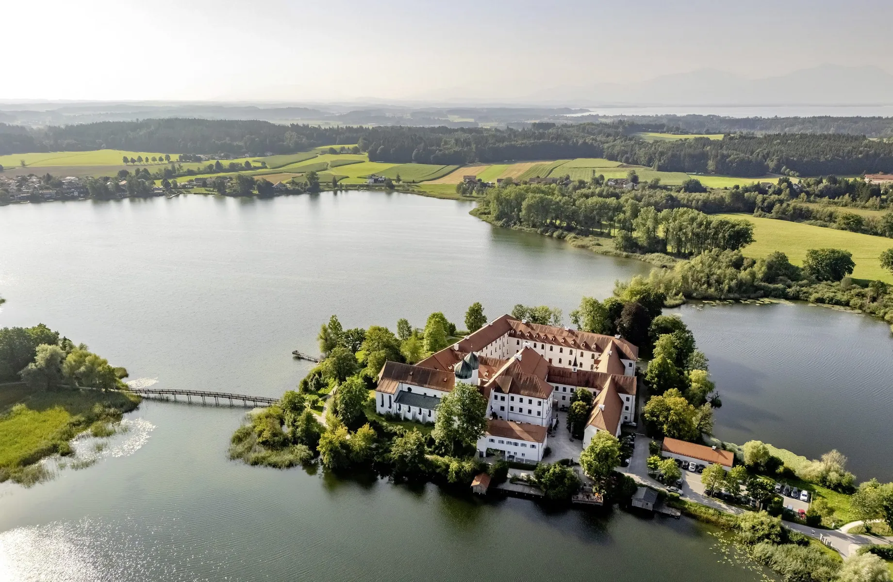 Ansicht der Klosteranlage des Kloster Seeon von oben inmitten des Sees