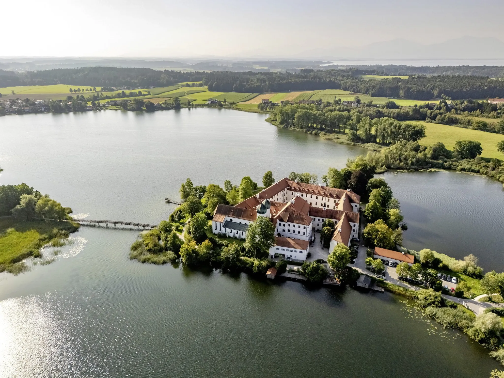 Ansicht der Klosteranlage des Kloster Seeon von oben inmitten des Sees