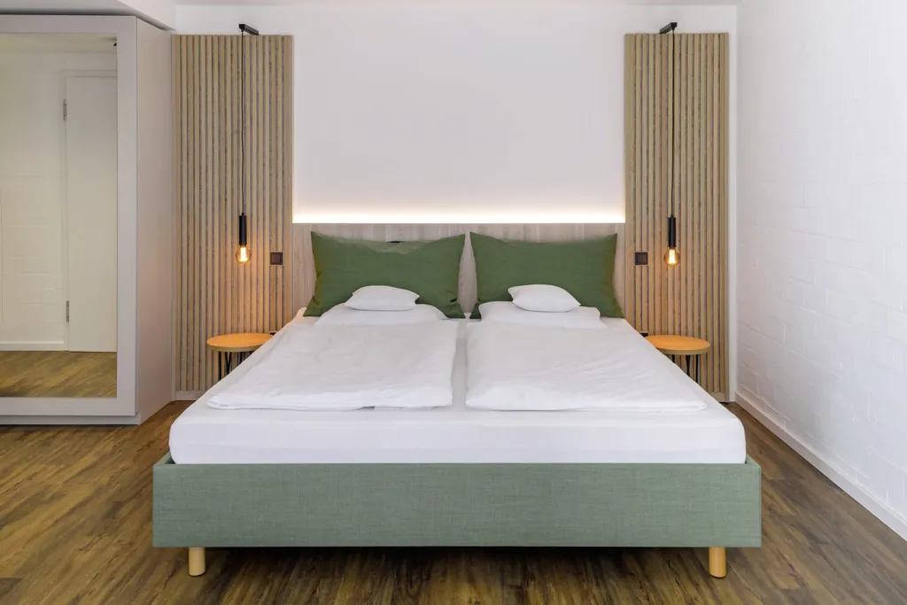 grünes Doppelbett im Westerham - die Akademie mit Holzpanelen an den Seiten