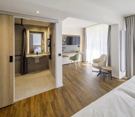 großes Zimmer in Westerham die Akademie mit Arbeitsbereich und Fernseher sowie Blick ins Bad