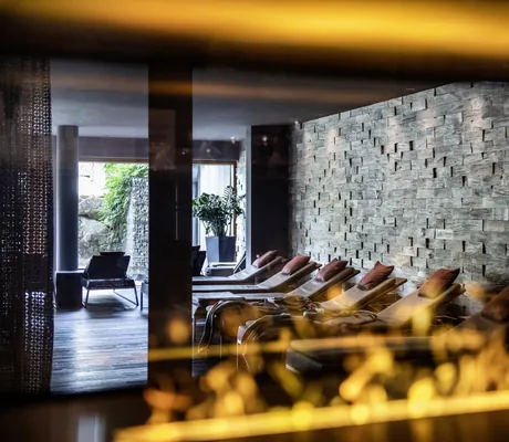 prasselndes Feuer im Kamin mit Blick auf den Ruherarum mit Granitwand im Bodenmaiser Hof