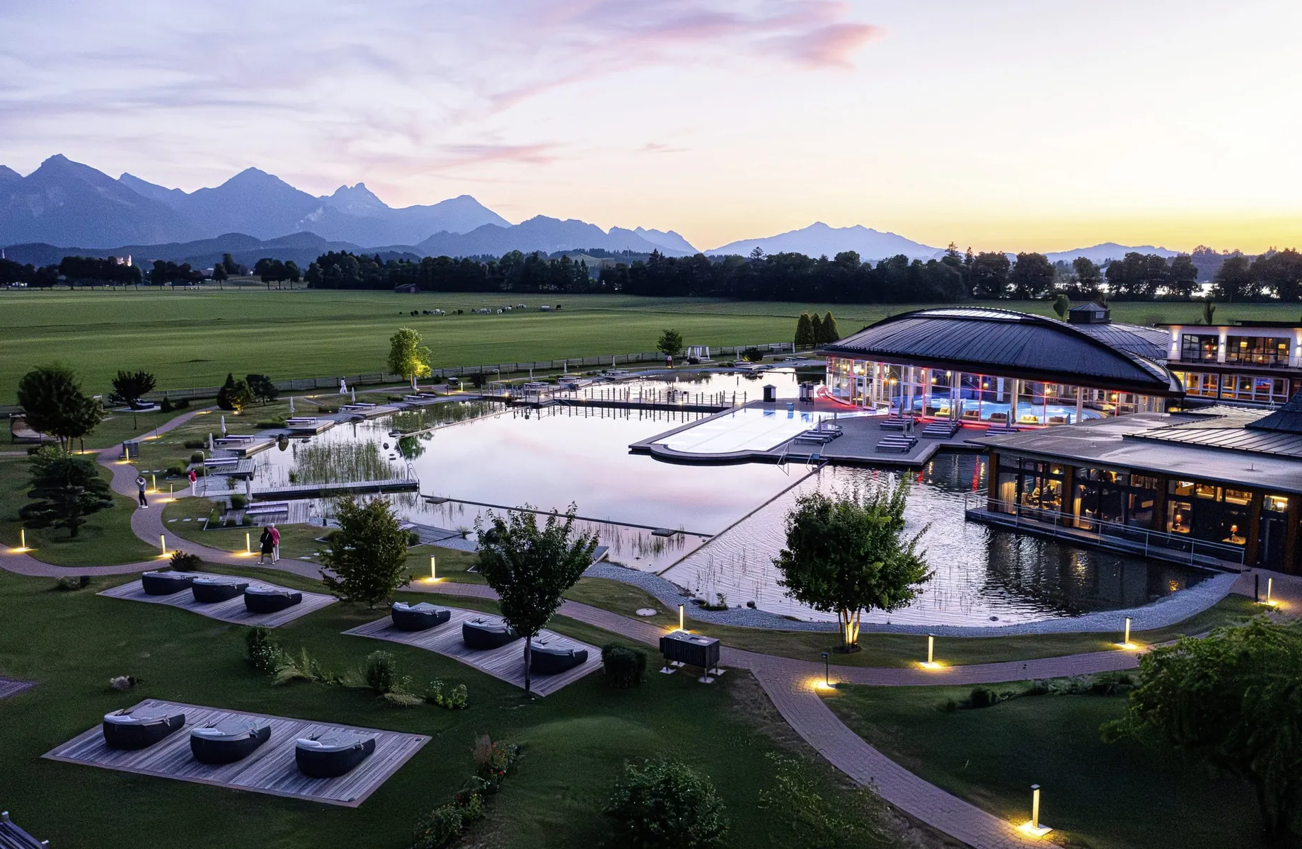 Blick von oben auf den riesigen Wellnessgarten des Wellnesshotels Das König Ludwig in Schwangau, im Hintergrund die Alpen