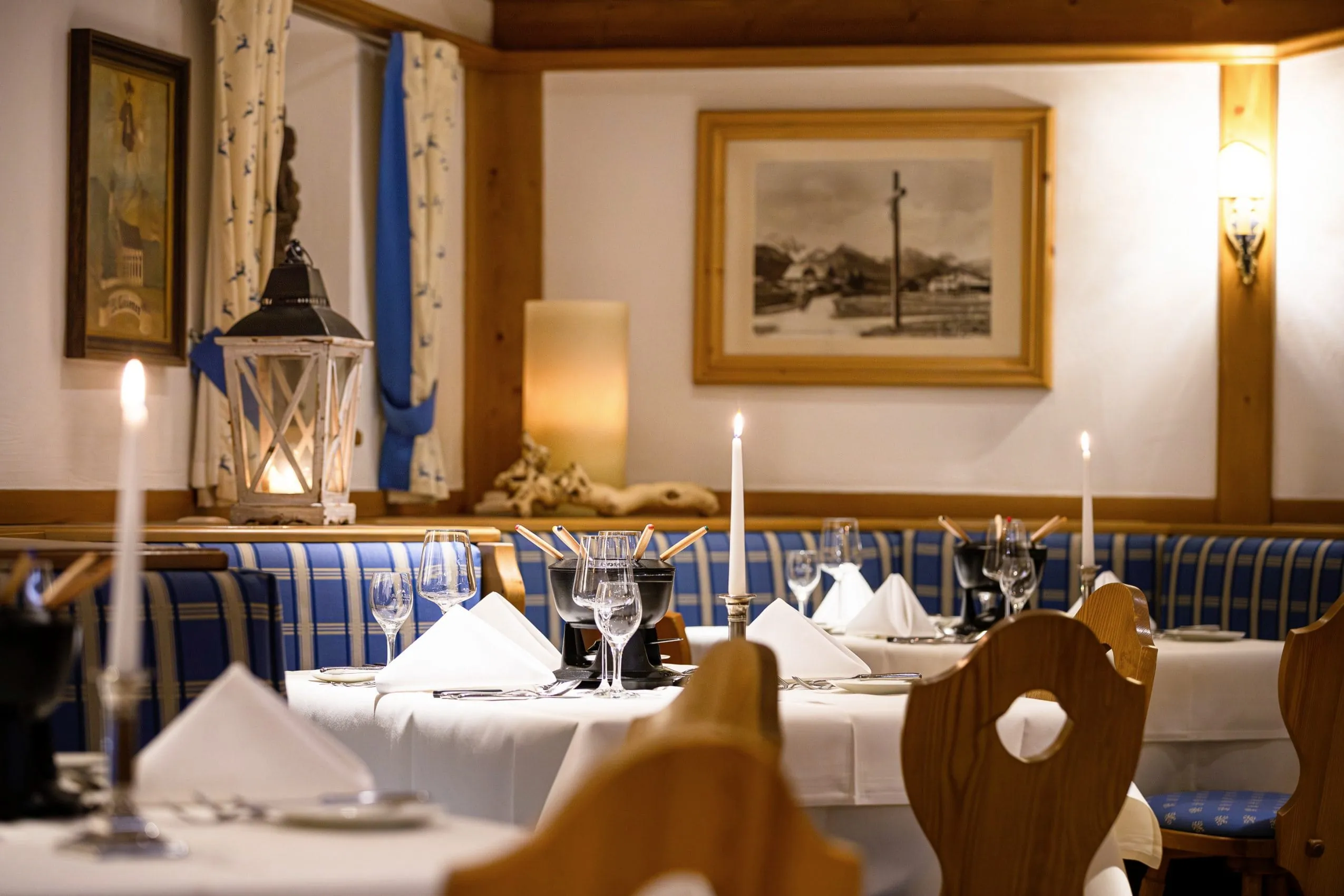 Gemütliche Restaurant-Stube mit eingedeckten Tischen und Fondue-Töpfen
