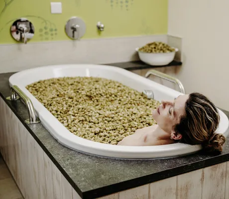 Frau liegt in Badewanne mit Hopfensud im Der Eisvogel