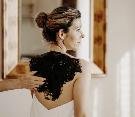 Frau mit Dutt erhält Moorpackung auf dem Rücken im Der Eisvogel