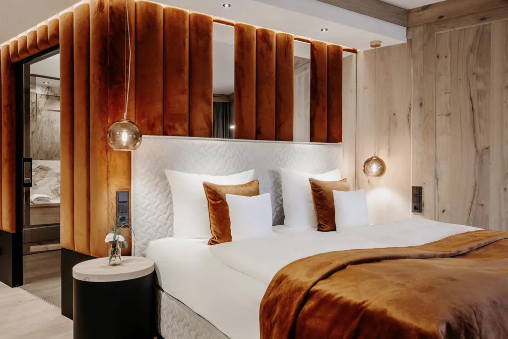 Doppelzimmer im Der Eisvogel mit rostrotem Bettüberwurf und rostroter Wandverkleidung