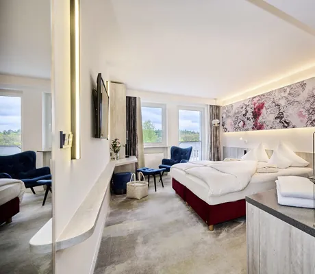 großes Zimmer in Die Wutzschleife mit blauem Samt-Sessel vor dem Fenster