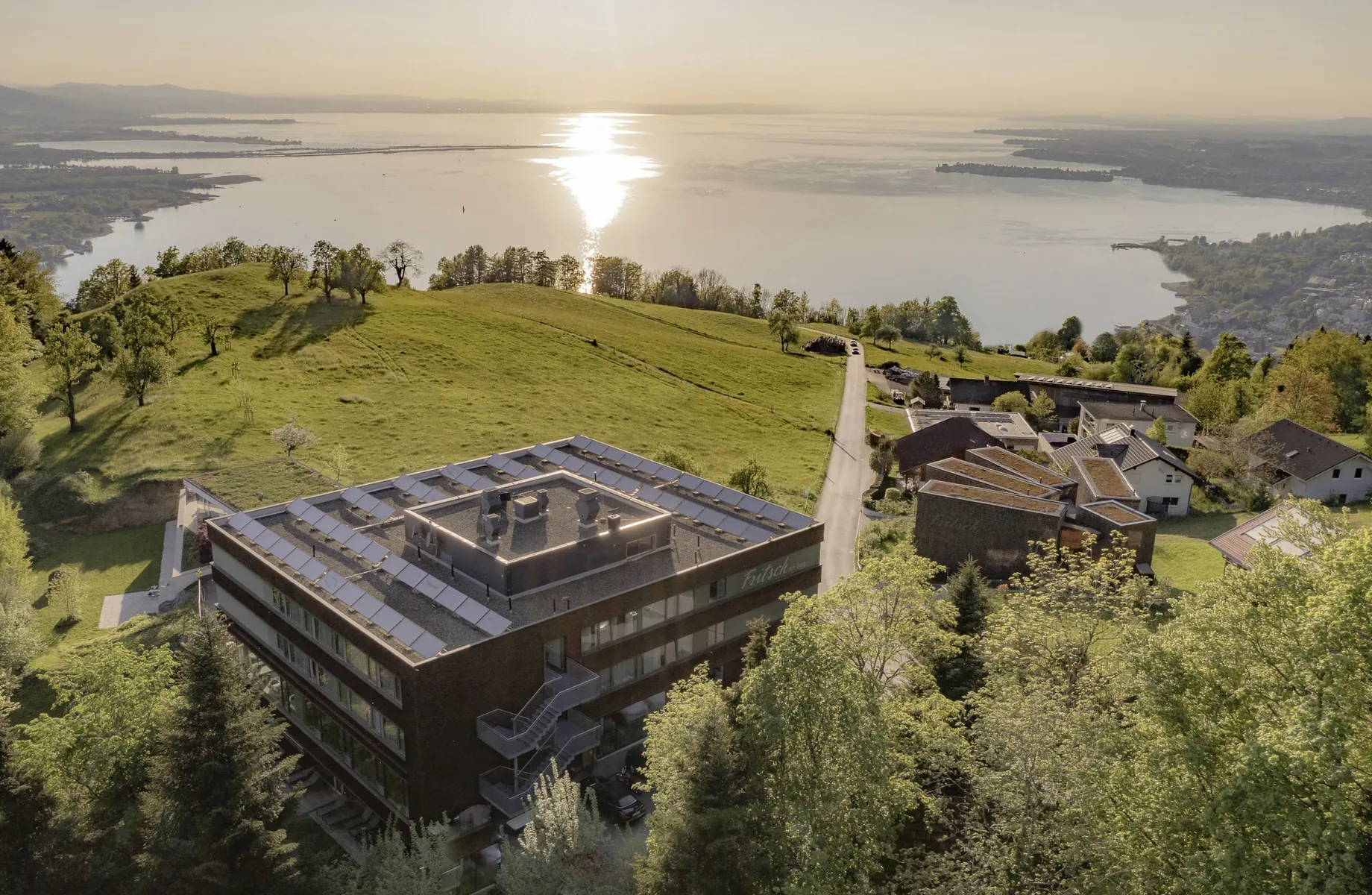 Luftaufnahme des Mental Spa Fritsch am Berg mit Blick auf den Sonnenuntergang am Bodensee