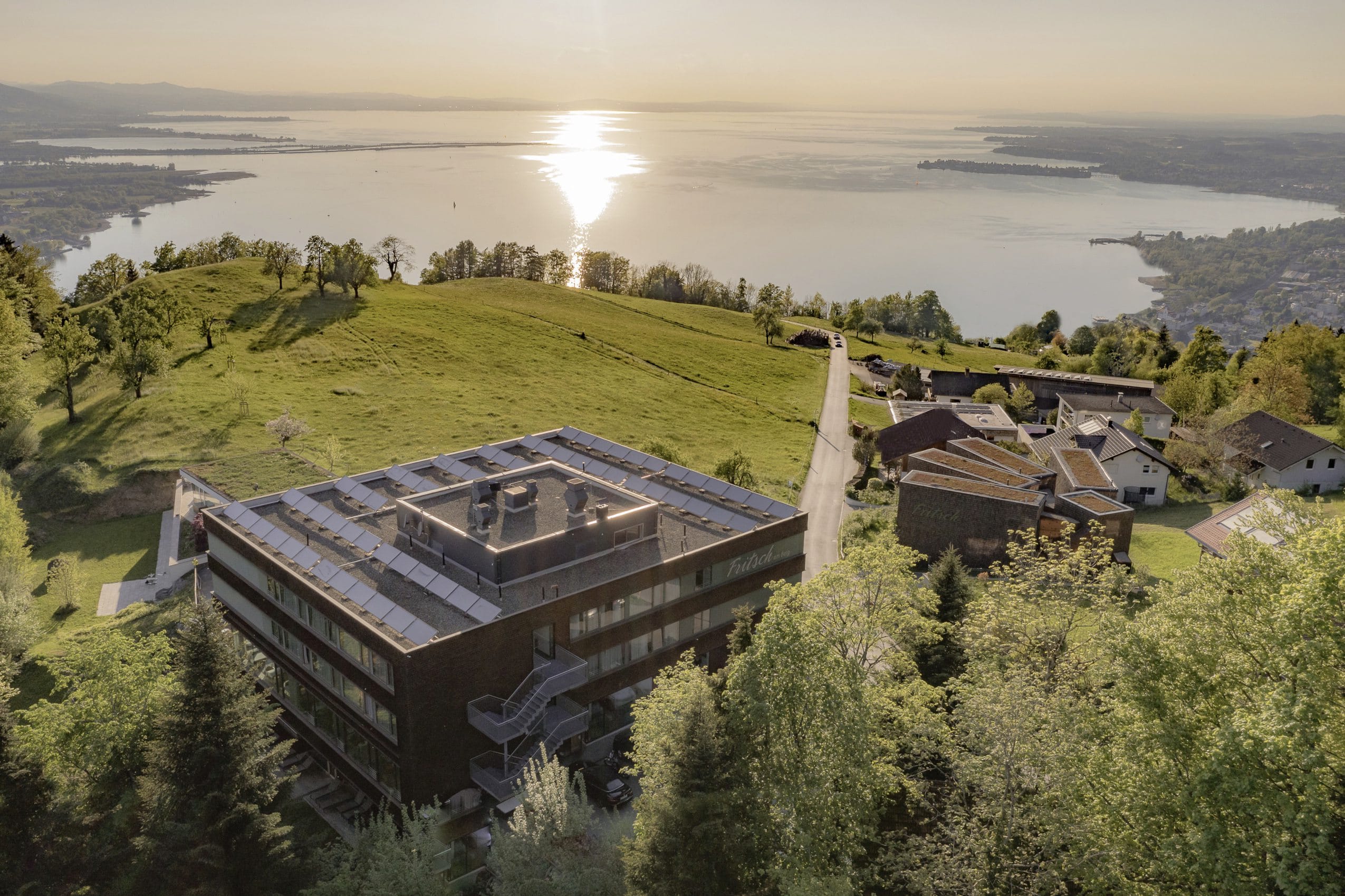 Luftaufnahme des Mental Spa Fritsch am Berg mit Blick auf den Sonnenuntergang am Bodensee