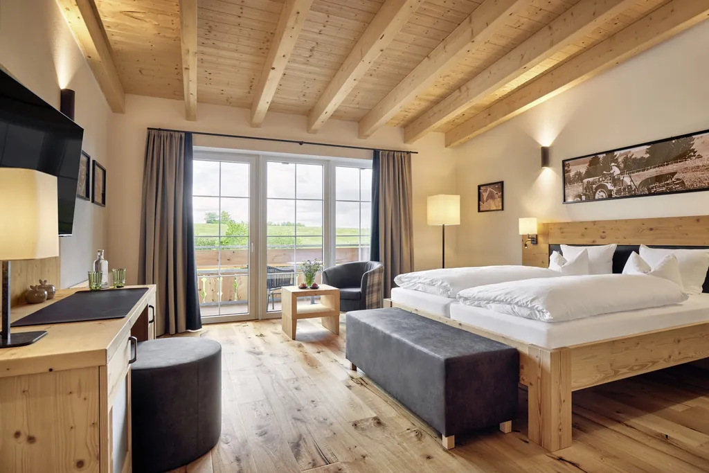 Doppelzimmer mit Holzboden und Holzdecke und Fotografie von Traktor im Hanusel Hof