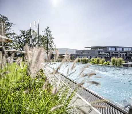 Outdoorpool mit Sprudelliegen vor der Fassade des Luisenhöhe Gesundheitsresort