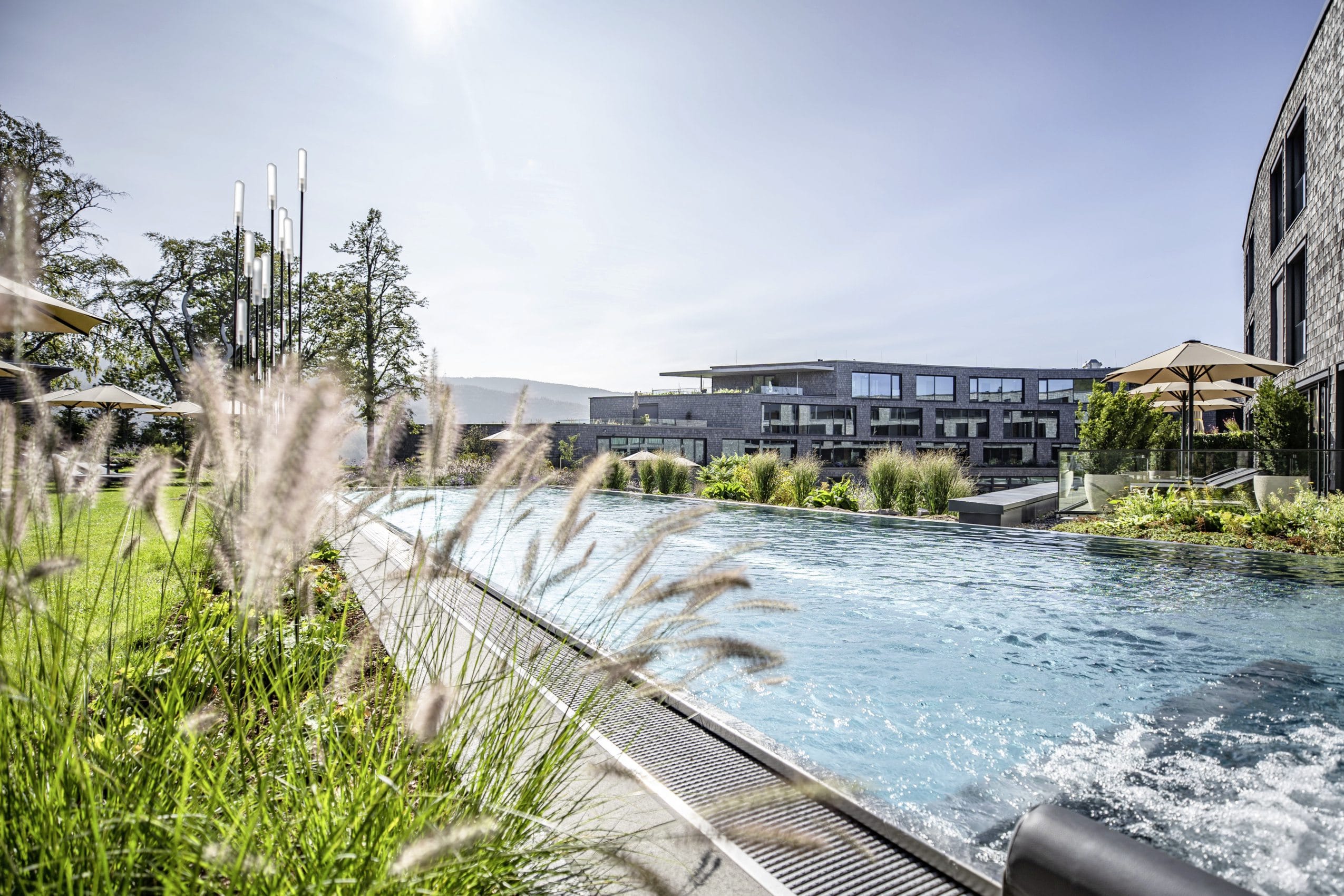 Outdoorpool mit Sprudelliegen vor der Fassade des Luisenhöhe Gesundheitsresort