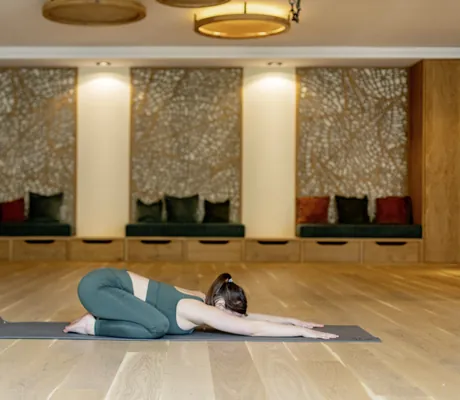 dunkelhaarige Frau in der Yogahaltung des Kindes im Yogaraum des Pfalzblick Wald Spa Resort