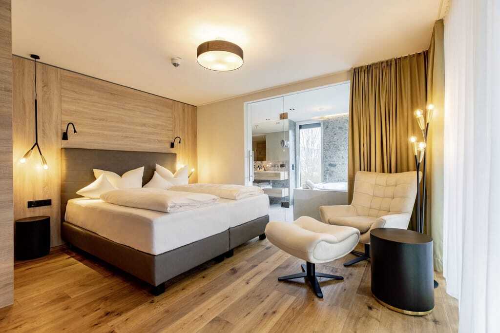 Doppelzimmer im Pfalzblick Wald Spa Resort mit weißem Sessel mit Fußteil