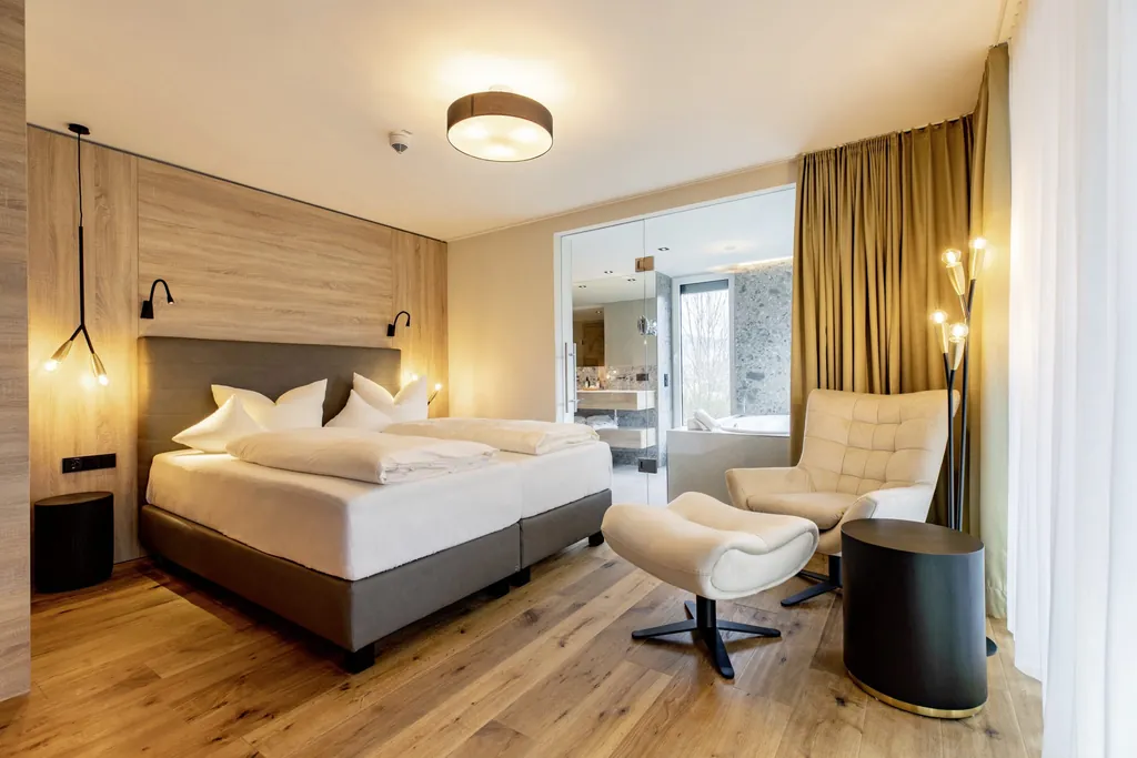 Doppelzimmer im Pfalzblick Wald Spa Resort mit weißem Sessel mit Fußteil