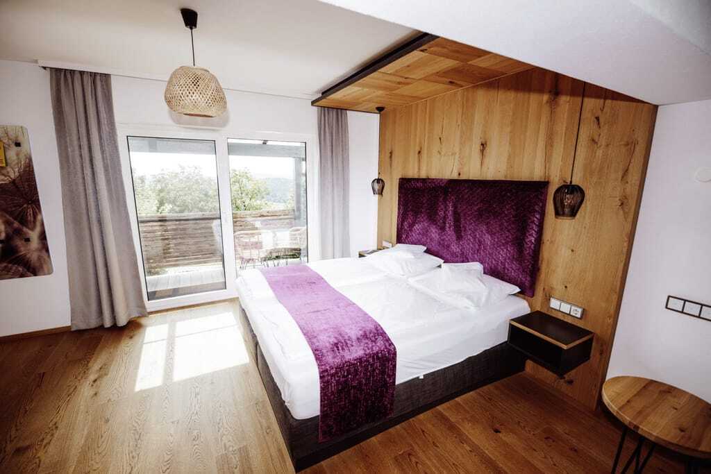 Doppelbett mit lila Bettrückwand und lila Überdecke in Thula Wellnesshotel