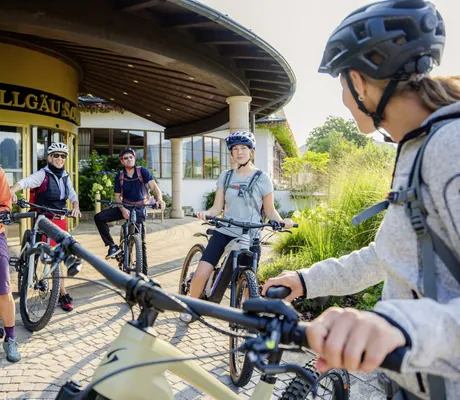 Gruppe von Radlern mit Helmen steht vor dem Eingang des Hotel Allgäu Sonne