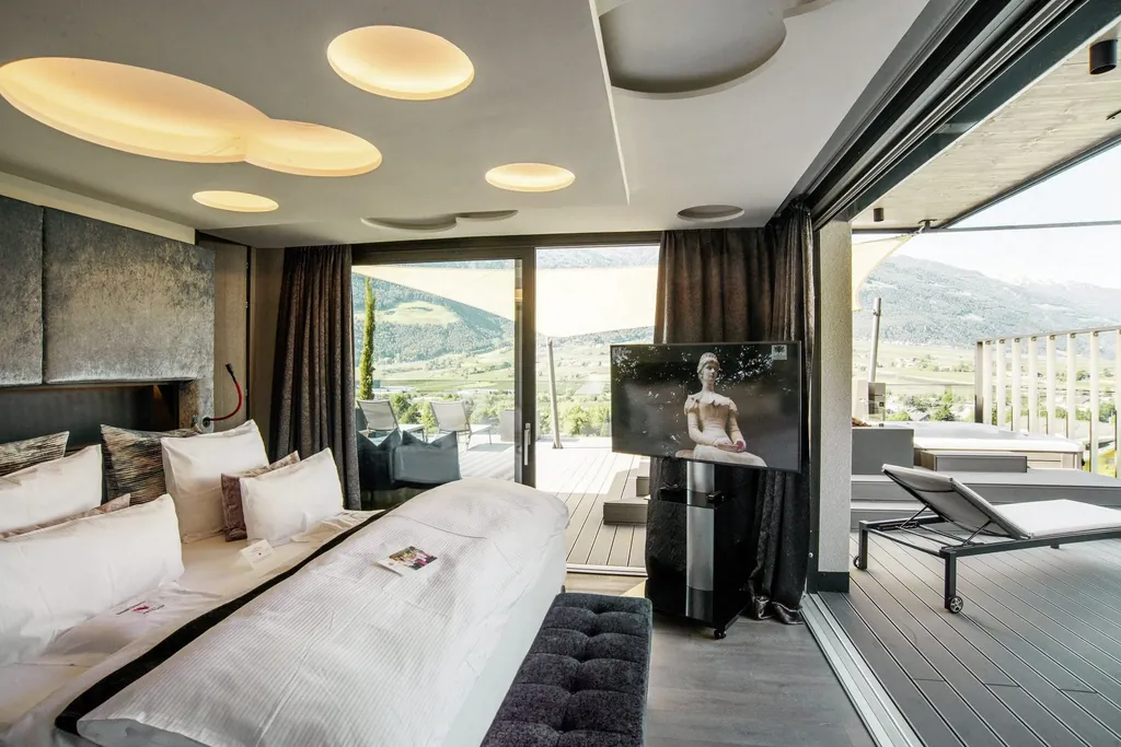 Zimmer im Preidlhof mit runden Elementen an der Decke und Zugang zu großer Terrasse