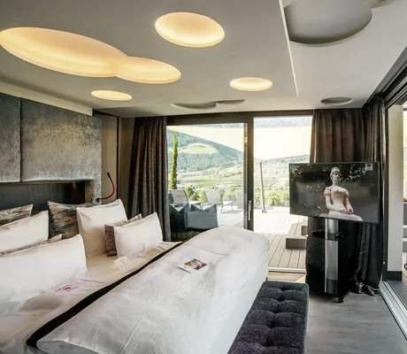 Zimmer im Preidlhof mit runden Elementen an der Decke und Zugang zu großer Terrasse